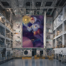 Load image into Gallery viewer, Large mural of a space-themed young woman in an industrial setting with a rocket.