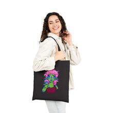 Load image into Gallery viewer, Woman holding a black tote bag with a colorful design on a white background